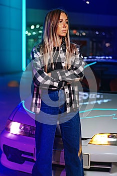 Young hipster girl near old sport car at night city