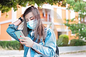 Young hipster girl with protective mask traveling alone around the city - Traveling woman with backpack on her shoulders checks