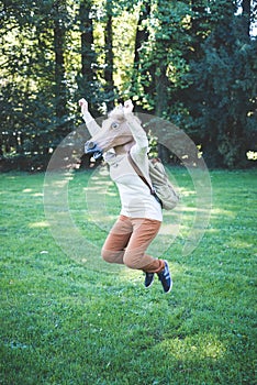 Young hipster horse mask woman in autumn