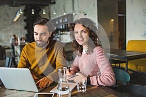 Young hipster male and female working laptop together in cafe