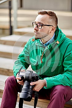 Young hipster man with digital camera in city