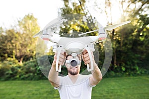 Young hipster man holding drone. Sunny green nature.
