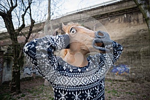 Young hipster man horse mask