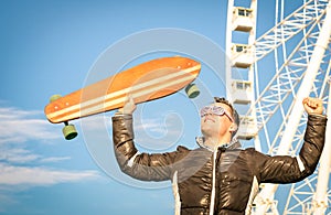 Young hipster man with longboard skate board at luna park