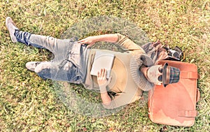 Young hipster man lying down with one tablet in his hands