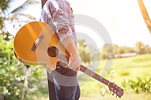 Young hipster man practiced guitar in the park,happy and enjoy playing guitar. photo