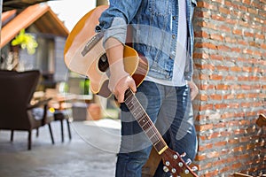 Young hipster man practiced guitar in the park,happy and enjoy playing guitar. photo