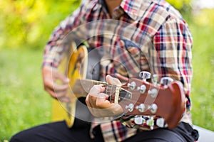 Close up of young hipster man practiced guitar in the park,happy and enjoy playing guitar	set photo
