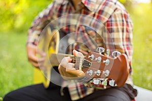 Close up of young hipster man practiced guitar in the park,happy and enjoy playing guitar	set photo