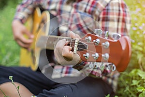 Close up of young hipster man practiced guitar in the park,happy and enjoy playing guitar	set photo