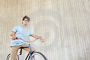 Young hipster man riding fixed gear bike