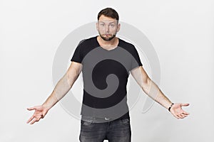 Young hipster man with surprised expression on face. Portrait against white wall