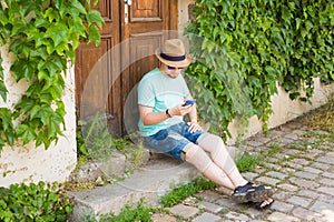 Young hipster man using mobile smart phone outdoors