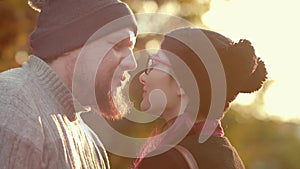 Young hipster mixed pace couple kiss at bright sunset. Man and a woman in love embracing at summer sunny day while