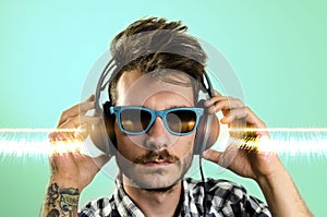Young hipster tattooed man, listening to music
