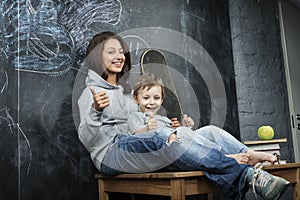 Young hipster teenage girl sitting with her brother in classroom multinational