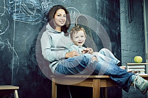 Young hipster teenage girl sitting with her little brother in classroom multinational, lifestyle people concept