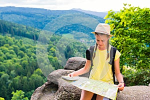 Young hipster tourist girl holding and looking map on trip; life