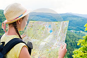 Young hipster tourist girl holding and looking map on trip; life