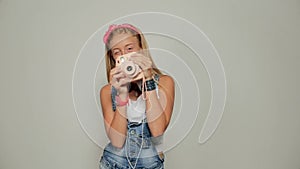 Young hipster woman holding retor insta polaroid camera taking photo portrait