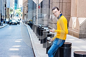 Young Hispanic American texting on cell phone, relaxing outside in New York City