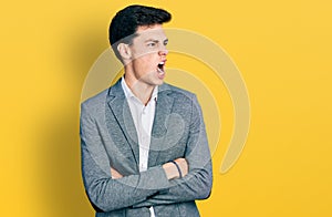 Young hispanic business man with arms crossed gesture angry and mad screaming frustrated and furious, shouting with anger