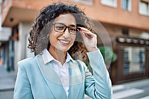 Young hispanic business woman wearing professional look smiling confident at the city