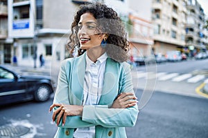 Young hispanic business woman wearing professional look smiling confident at the city