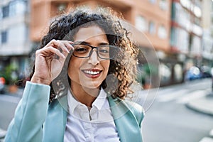 Young hispanic business woman wearing professional look smiling confident at the city