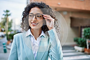 Young hispanic business woman wearing professional look smiling confident at the city