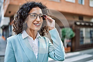 Young hispanic business woman wearing professional look smiling confident at the city