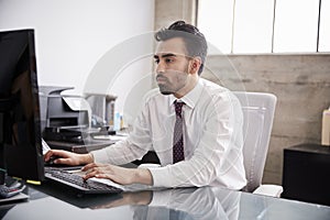 Young Hispanic businessman using computer in an office