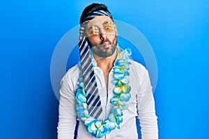 Young hispanic businessman wearing party funny style with tie on head making fish face with lips, crazy and comical gesture