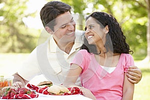 Young Hispanic Couple Enjoying Picnic In Park