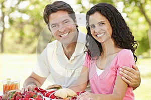 Young Hispanic Couple Enjoying Picnic In Park