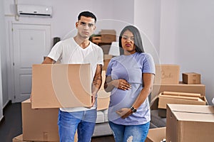 Young hispanic couple expecting a baby moving to a new home skeptic and nervous, frowning upset because of problem