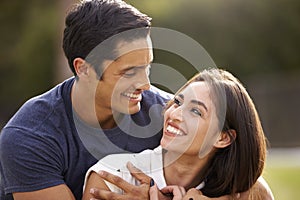 Young Hispanic couple looking at each other smiling, close up