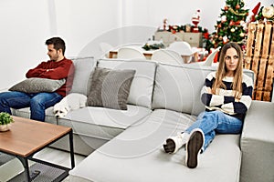 Young hispanic couple with problems sitting on the sofa in silence at home