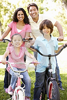 Young Hispanic Family Cycling In Park