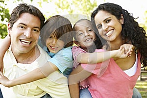 Young Hispanic Family Having Piggyback In Park