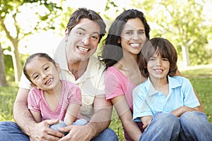 Young Hispanic Family Relaxing In Park