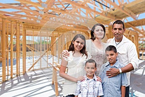 Young Hispanic Family On Site Inside New Home Construction Framing.