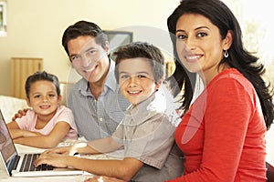 Young Hispanic Family Using Computer At Home