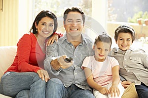 Young Hispanic Family Watching TV At Home