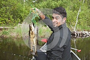 Young Hispanic fisherman holds up a stringer of walleyes