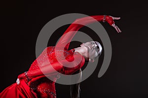 Young hispanic flamenco dancer in red dress isolated on black background