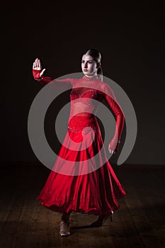 Young hispanic flamenco dancer in red dress isolated on black background