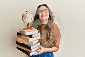 Young hispanic girl studying geography smiling with a happy and cool smile on face