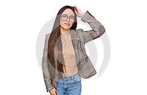 Young hispanic girl wearing business clothes and glasses confuse and wonder about question