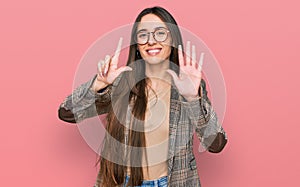 Young hispanic girl wearing business clothes and glasses showing and pointing up with fingers number seven while smiling confident